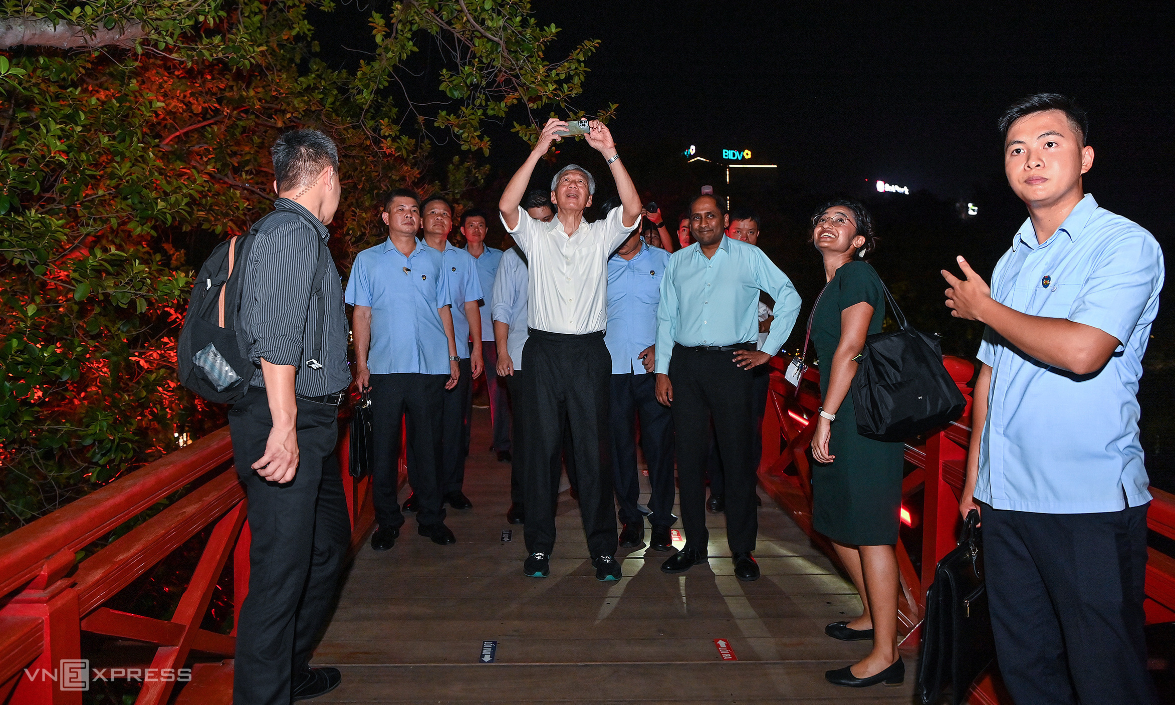 Thủ tướng Singapore Lý Hiển Long (áo trắng) thích thú chụp ảnh tại Cầu Thê Húc trước khi vào thăm đền Ngọc Sơn. (Nguồn ảnh: Lấy từ trang VnExpress)